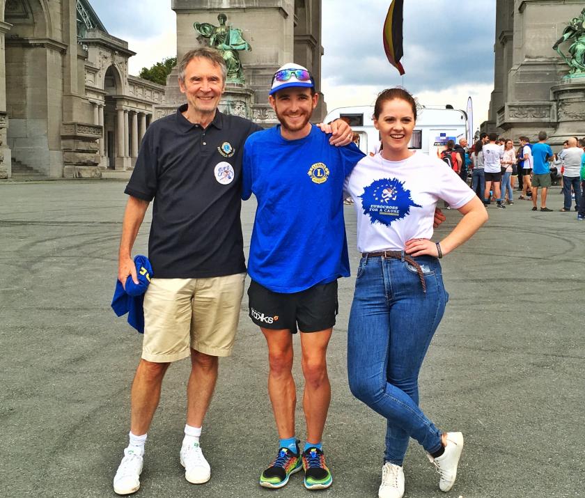 Super marathon Eurocross project fights obesity. Lion Terry Davidson, Ralph Mesquita and  logistics manager Maddy (daughter of Lion Dominic Kelleher) welcome Ralph as he reaches  3000 km stage in Brussels Cinquantenaire.
